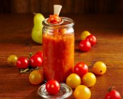 Chutney de tomate casero con pera, jengibre, vinagre, tomates cherry, chile, cilantro, clavo de olor y tomillo - foto de stock