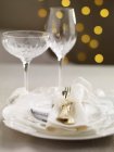 Una tavola di Natale con un fiocco bianco e bicchieri di cristallo — Foto stock