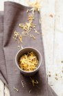 Dried chamomile flowers in a bowl on a wooden background — Stock Photo
