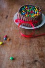 Un pastel de chocolate con barras de chocolate en una mesa de madera con una cinta roja para el Día de la Madre - foto de stock