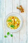 Macarrones con tomates amarillos, mozzarella y albahaca - foto de stock