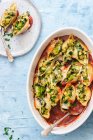 Pasta shells with zucchini, broccoli florets and mozzarella in tomato sauce — Stock Photo