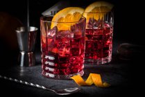 Classic Italian cocktail: Negroni on ice with oranges in glasses — Stock Photo