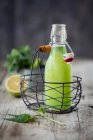 Orties limonade en mini bouteille à l'intérieur mini panier de fil — Photo de stock