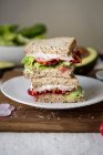 Avocado vegetable sandwiches stacked on plate — Stock Photo