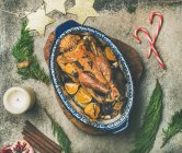 Roasted chicken for Christmas eve celebration table with holiday decorations on wooden board — Stock Photo