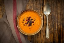 Oriental carrot, ginger and coconut soup with black sesame seeds and pomegranate seeds — Stock Photo