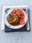Une aubergine farcie servie avec salade de tomates — Photo de stock