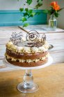 Um bolo de creme de manteiga com decorações de chocolate filigrana — Fotografia de Stock