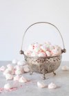 Vintage metal bowl with handle filled with pink sprinkled meringues — Stock Photo