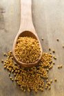 Whole buckwheat bran seeds on wooden spoon — Stock Photo