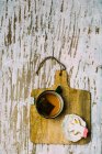 Печенье из единорога с чашкой чая на деревянной доске на белой поверхности — стоковое фото