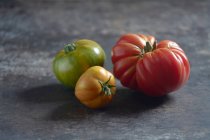 Los tomates de cebra y el tomate de buey en la chapa metálica - foto de stock