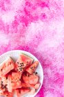 Rodajas de sandía sobre plato de cerámica sobre fondo rosa - foto de stock