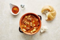 Goulash soup with potatoes and bread rolls — Stock Photo