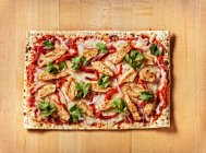 Churrasco Frango Flatbread Pizza na mesa bloco de açougue com coentro, pimentas vermelhas torradas e queijo branco mussarela — Fotografia de Stock