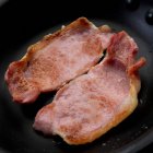 Fried English style bacon in skillet — Stock Photo
