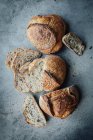 Расположение хлеба с нарезанными хлебами на серой поверхности — стоковое фото