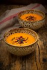 Восточная морковь, имбирный и кокосовый суп с черными семенами кунжута и семенами граната — стоковое фото