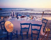 Laid table on the beach at twilight — Stock Photo