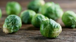 Fresh green brussels sprouts on wooden table — Stock Photo