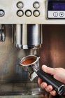 Filterhalter mit frisch gemahlenem Kaffee an der Kaffeemaschine befestigen — Stockfoto