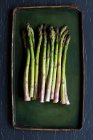 Fresh green asparagus on a black background — Stock Photo