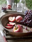 Metallsieb mit Trauben und geschnittenen und ganzen Pfirsichen — Stockfoto