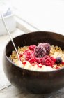 Un bol à smoothie avec granola, banane et fruits rouges surgelés — Photo de stock