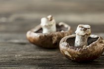 Two portobello mushrooms on a wooden surface — Stock Photo