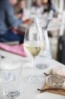 Бокал белого вина с водой, солью и перцем на столе в ресторане — стоковое фото