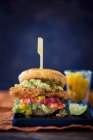 A burger with chicken breast, pineapple, avocado, prawns and mango chutney — Stock Photo