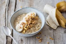 Rice porridge made with lupin and coconut milk with banana and crunchy flakes — Stock Photo