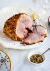 Glazed ham and coarse mustard garnished with carnations — Stock Photo