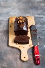 Chocolate cake on a wooden plank on a grey backdrop — Stock Photo