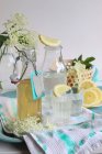 Jarabe de flor de saúco en una botella y se vierte en vasos con rodajas de limón - foto de stock