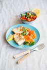 Salmon fillet with carrots and a tomato and avocado salad — Stock Photo