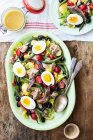 Салат никоз с салатом ромейн, помидоры черри, тунец, зеленая фасоль, черные оливки, анчоусы и яйца варёные — стоковое фото