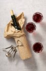 Una bottiglia di vino confezionato, bicchieri di vino rosso, e un cavatappi — Foto stock