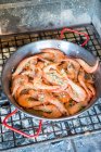 Prawns with garlic in a pan on a grill — Stock Photo