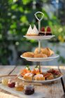 Various canapes and sweet pastries on a cake stand for tea — Stock Photo