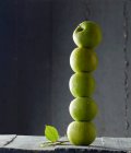 Green apples stacked in a tower — Stock Photo