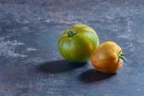 Tomates zébrées vertes et oranges sur une tôle — Photo de stock