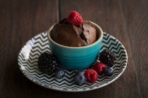 Schokoladenkuchen mit flüssigem Kern, garniert mit Beeren — Stockfoto