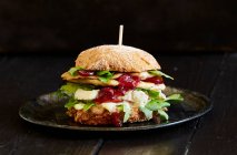 Una hamburguesa de pollo con camembert y salsa de arándanos - foto de stock