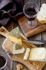 Cheese platter with bread, walnuts and red wine — Stock Photo