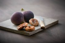 Свежий и сушеный инжир на деревянной доске — стоковое фото
