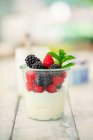 Cottage cheese with fresh raspberries and blackberries and mint in glass — Stock Photo