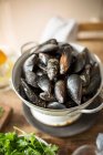Raw mussels in colander — Stock Photo