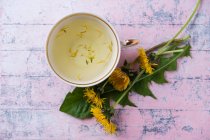 Травяной чай с лимоном и липовыми цветами на деревянном фоне — стоковое фото